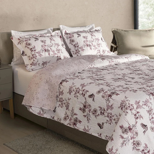 Cama arrumada com cobre-leito matelassê e porta-travesseiros