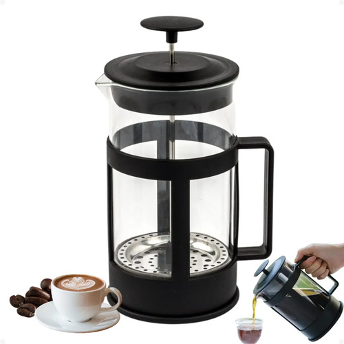 Prensa francesa de vidro com estrutura preta, ao lado de uma xícara de café e grãos