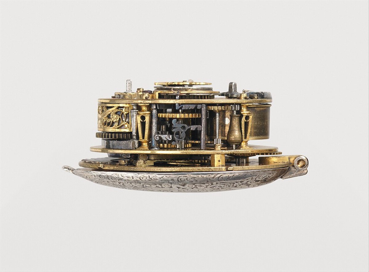 Mecanismo dourado de um relógio de bolso do século XVII, com despertador e calendário